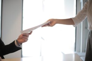 muher recebendo a certidão de onus reais do imovel que está comprando